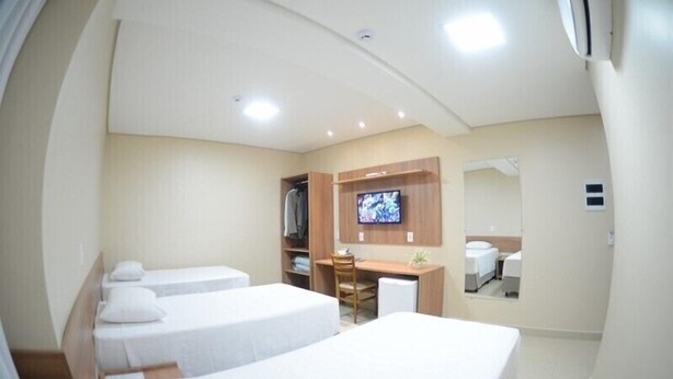 A hotel room with two beds, a desk, a TV, a wardrobe, and a mirror. - Hotel Portal da Amazônia (Varzea Grande)