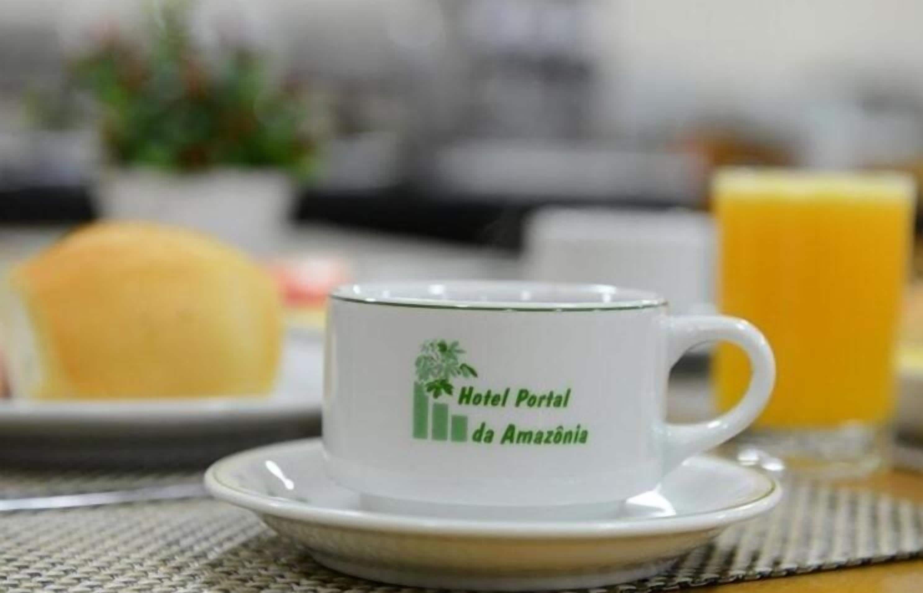 A white cup with a logo and text on a saucer, placed on a table with a placemat.