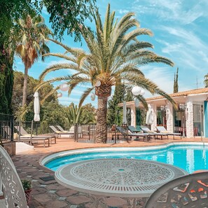 Una piscina al aire libre de temporada, sombrillas