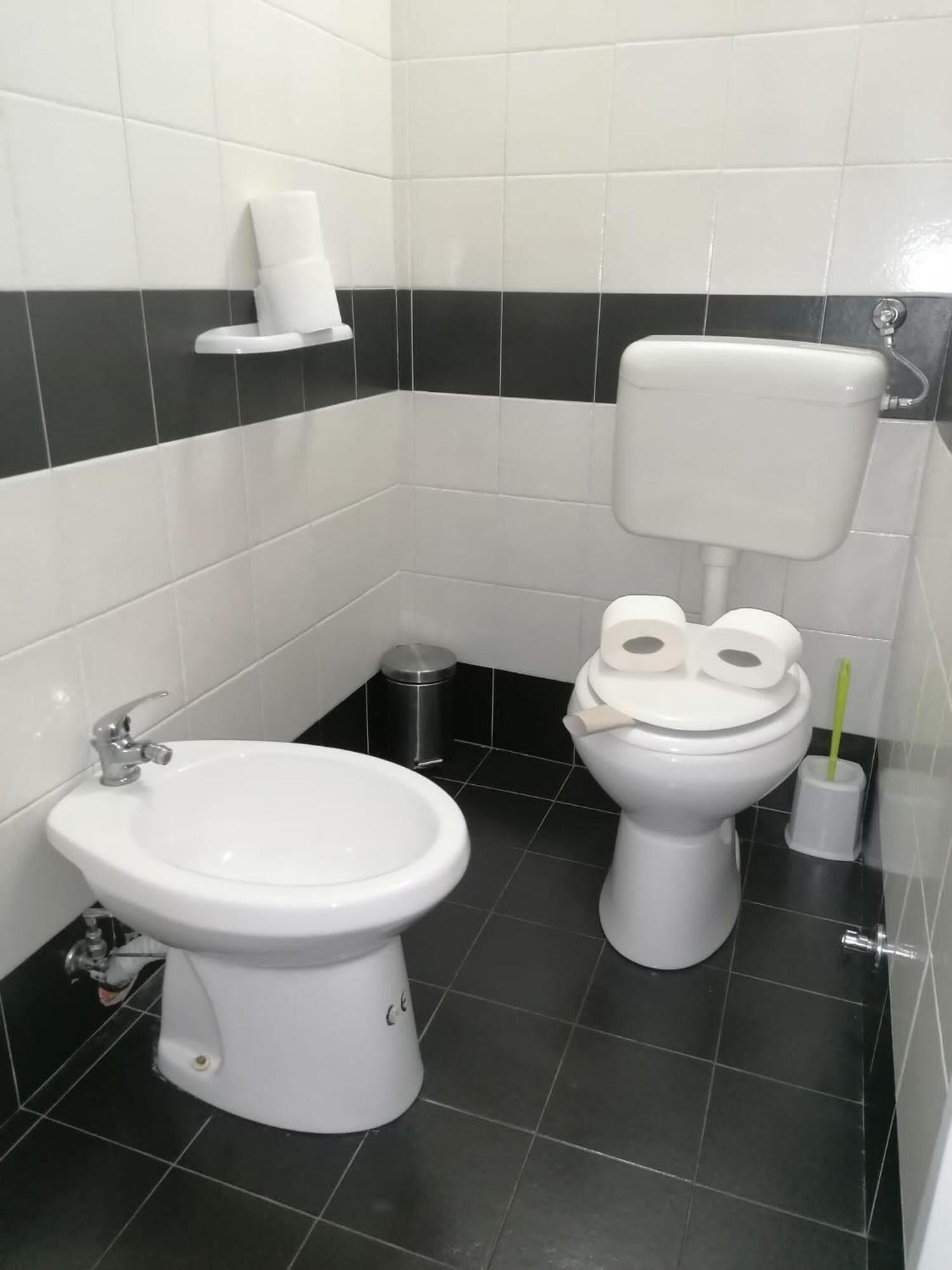 A bathroom with a toilet, bidet, and sink.