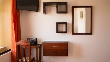 Una habitación con escritorio, silla y un espejo grande.