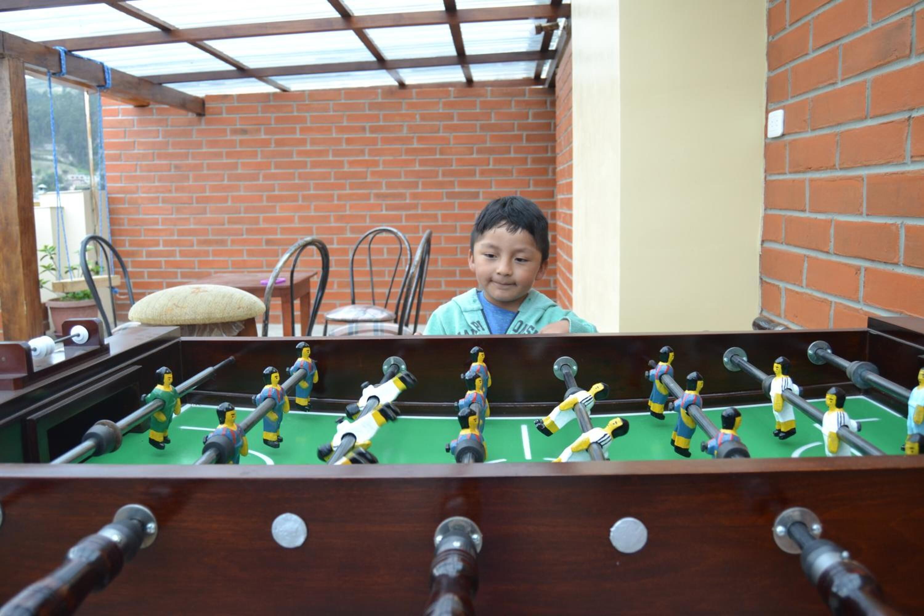 A foosball table in a room with brick walls and a wooden ceiling.
