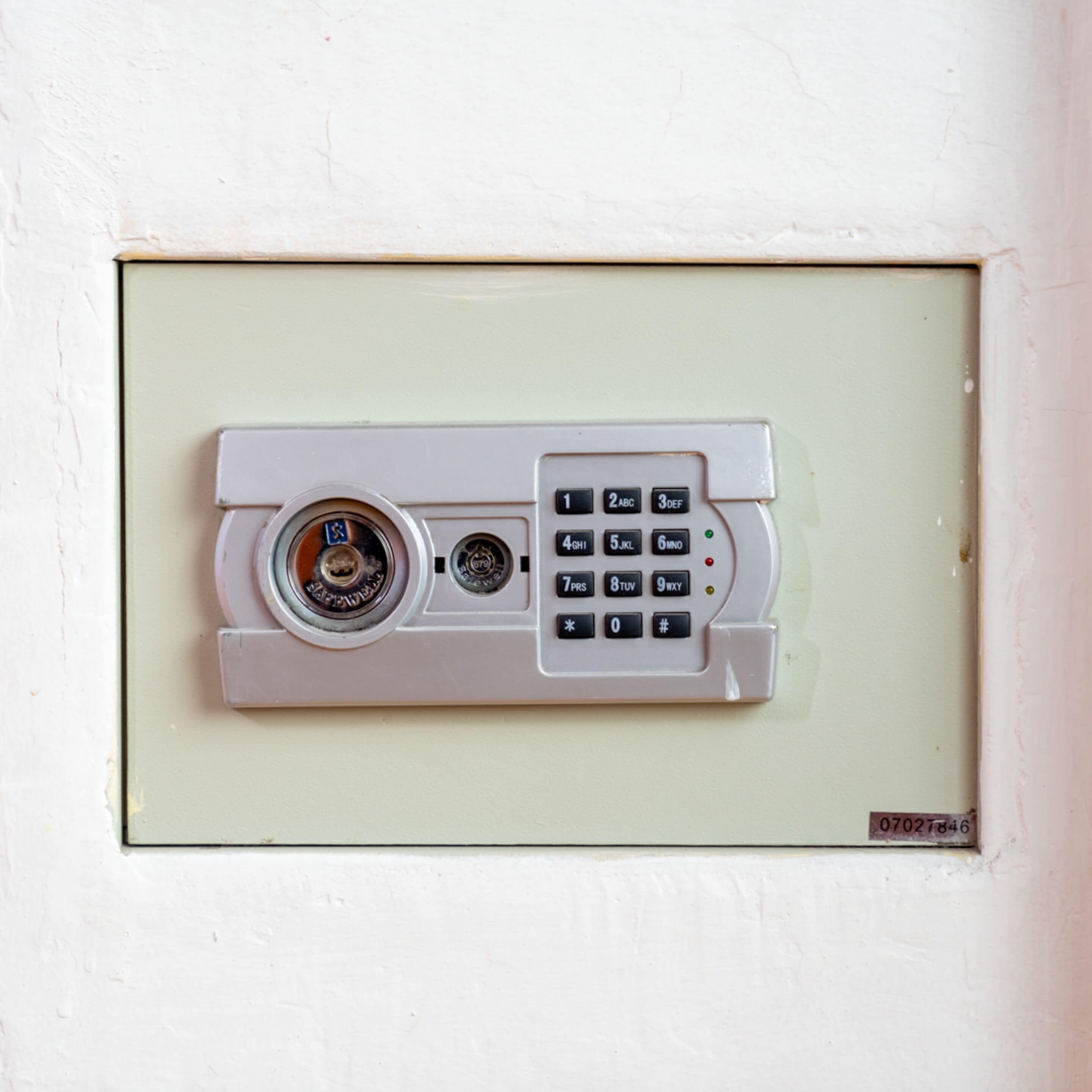 A security keypad with a lock mechanism, a keyhole, and a small label with numbers.