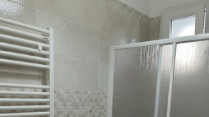 A bathroom with a toilet, bidet, and a shower enclosure. - B&B La Maison (Gallipoli)