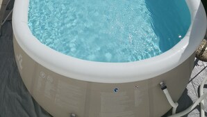 An outdoor swimming pool with a ladder, surrounded by a tiled patio. - B&B La Maison (Gallipoli)