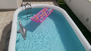 An outdoor swimming pool with a pink floating mat and a metal ladder. - B&B La Maison (Gallipoli)