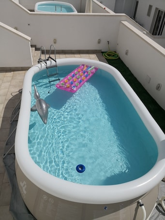 Una piscina al aire libre de temporada, sombrillas