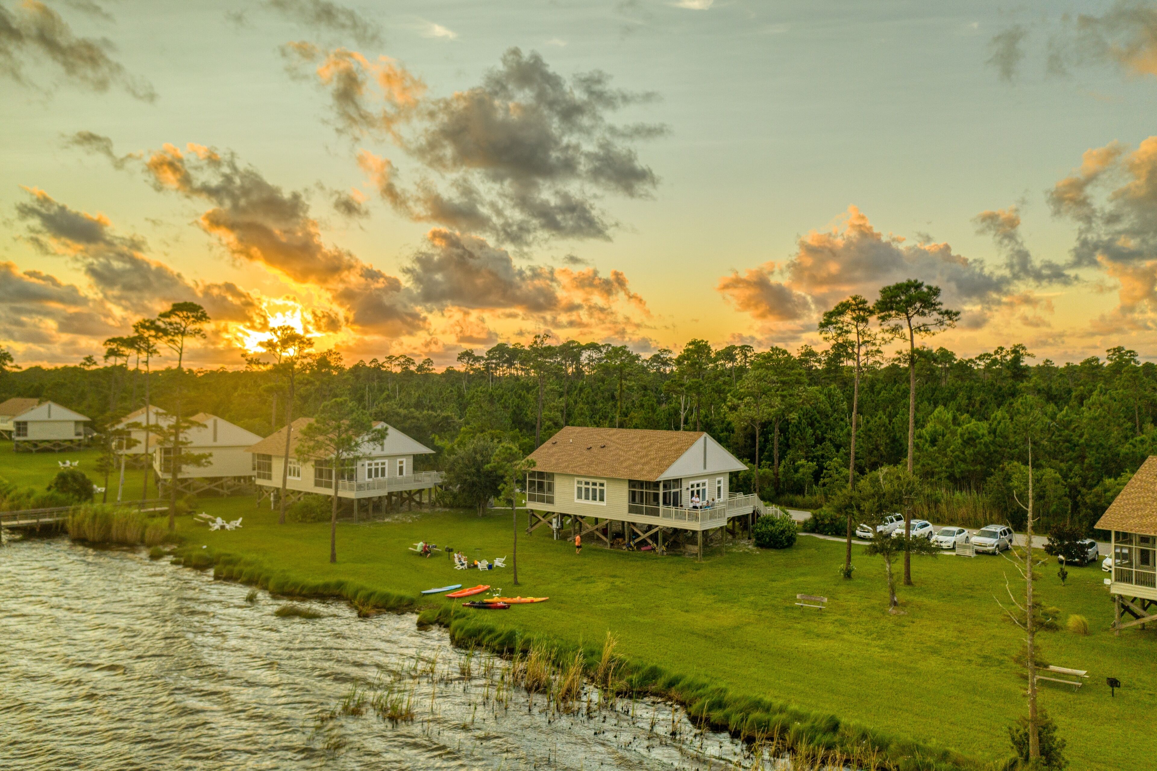 A lakeside property with multiple houses, a dock, and boats.