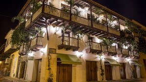 A multi-story building with balconies, wooden doors, and outdoor plants. - Leones de Alba Hotel Boutique (Cartagena)