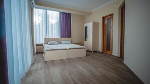 A bedroom with a bed, a wardrobe, a nightstand, and a window with curtains. - Private Villa Guest House (Khelvachauri)
