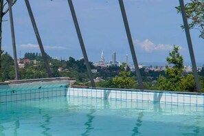 A swimming pool with a view of a cityscape in the background. - Private Villa Guest House (Khelvachauri)
