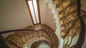 A spiral staircase with a geometric railing design, leading to a landing with a window. - Private Villa Guest House (Khelvachauri)