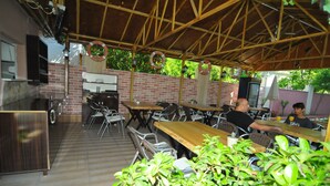 An outdoor dining area with brick walls, wooden tables, and chairs.