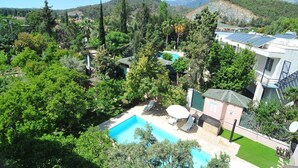 A pool area with a clear view of the surrounding landscape, including trees and distant mountains.