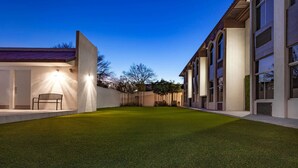 A modern building with a well-maintained lawn and a bench. - Days Inn by Wyndham Piedras Negras (Piedras Negras)