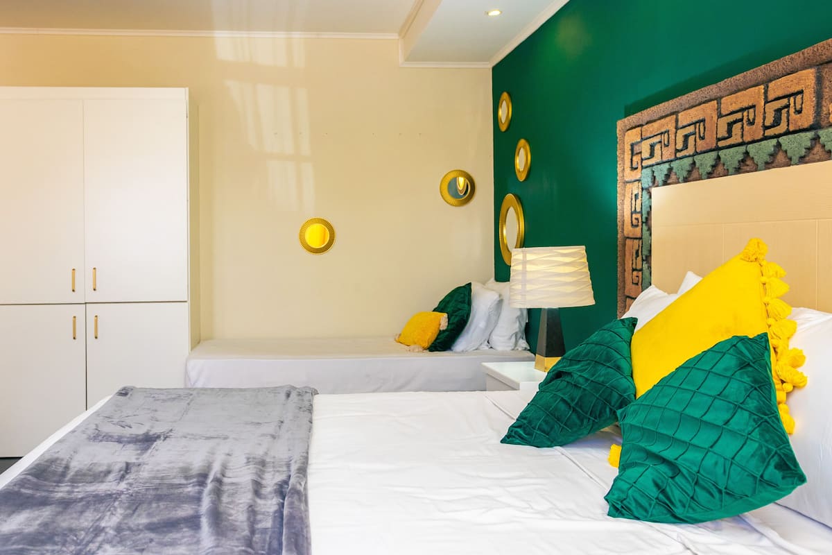 A hotel room with a bed, a nightstand, a lamp, and a wardrobe.