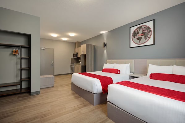 Une chambre d’hôtel avec deux lits, une kitchenette et une salle de bain.