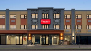 A multi-story hotel with a prominent red sign reading "RAMADA BY WYNDHAM".