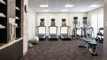 A gym with treadmills, elliptical machines, and weight equipment.