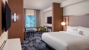 A hotel room with a large bed, a desk, a chair, a television, and a window with curtains. - Fairfield by Marriott Inn & Suites Pensacola Pine Forest (Pensacola)