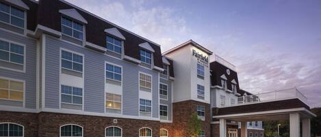 A hotel with a brick facade, large windows, and a covered entrance.