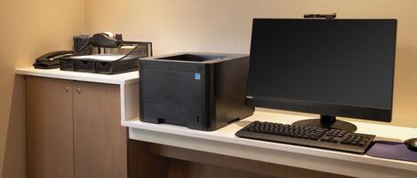A desk with a computer, keyboard, and a printer.