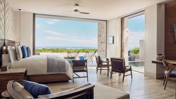 A modern bedroom with a large bed, a balcony with a view, and a dining area.