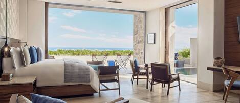 Un dormitorio moderno con una cama grande, un balcón con vistas y una zona de comedor.