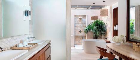 Un baño moderno con un espejo grande, lavamanos dobles, una bañera y un mueble de tocador de madera.