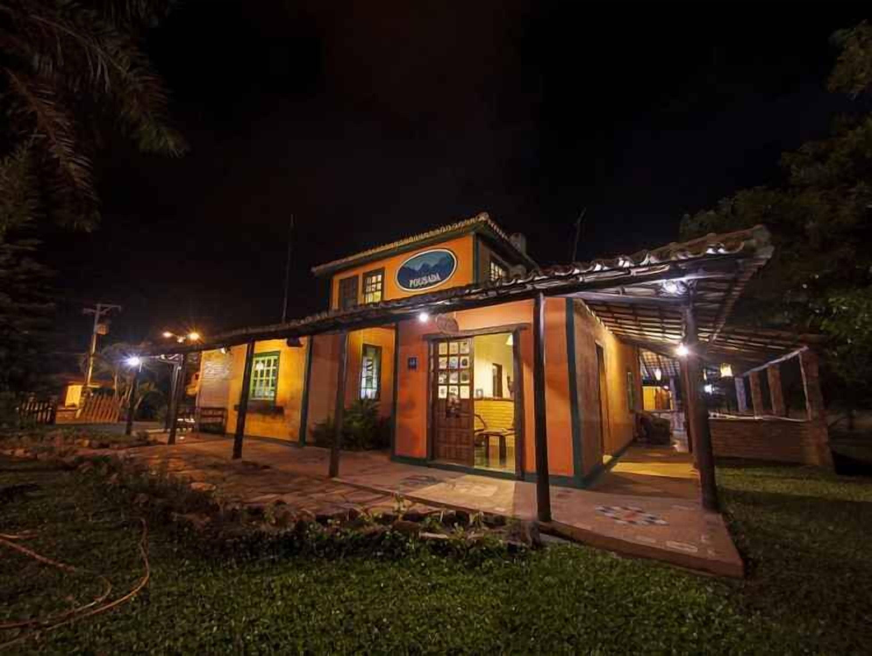 Un edificio de dos pisos con un espacio al aire libre cubierto y un letrero que indica que es un restaurante.