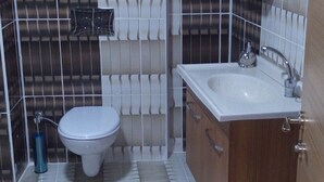 Ein Badezimmer mit Toilette, Waschbecken und Holzschränken.