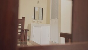 A bathroom with a white sink, mirror, and cabinets. - Hotel Villa Calakmul (Calakmul)