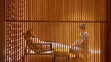 A room with a wooden slat partition, a bed, and a chair.