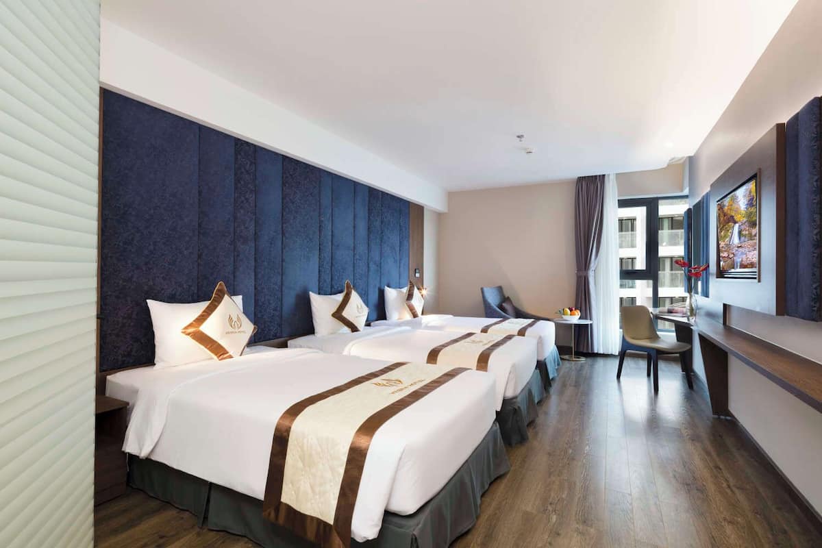 A hotel room with a large bed, a desk, and a view of a building.