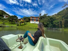 Una persona sentada en un bote con vista a un lago, un puente y un edificio al fondo.