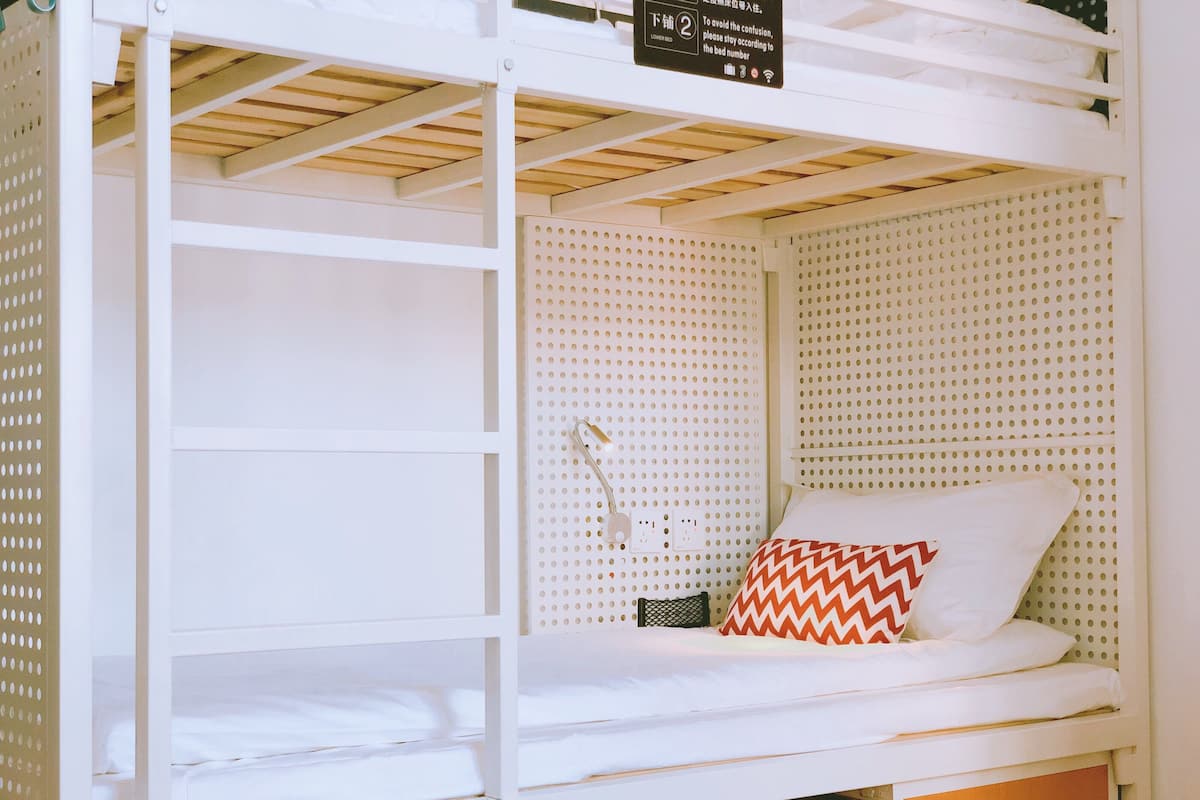 A bunk bed with a lower bed and a higher bunk. There is a sign indicating bed numbers.