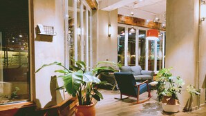 A cozy indoor seating area with a sofa, rocking chair, and potted plants.