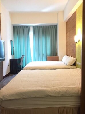 Una habitación de hotel con dos camas, un escritorio y una silla.