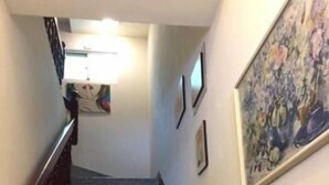 A staircase with granite steps and wooden handrails, leading to a landing with a light fixture. - U-Lu B&B (Hualien City)