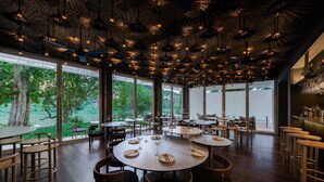 A restaurant with round tables, chairs, and hanging light fixtures. - Little Shelter Hotel Chiangmai  (Chiang Mai)