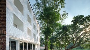 A modern building with a pool, outdoor seating, and a view of a lake. - Little Shelter Hotel Chiangmai  (Chiang Mai)