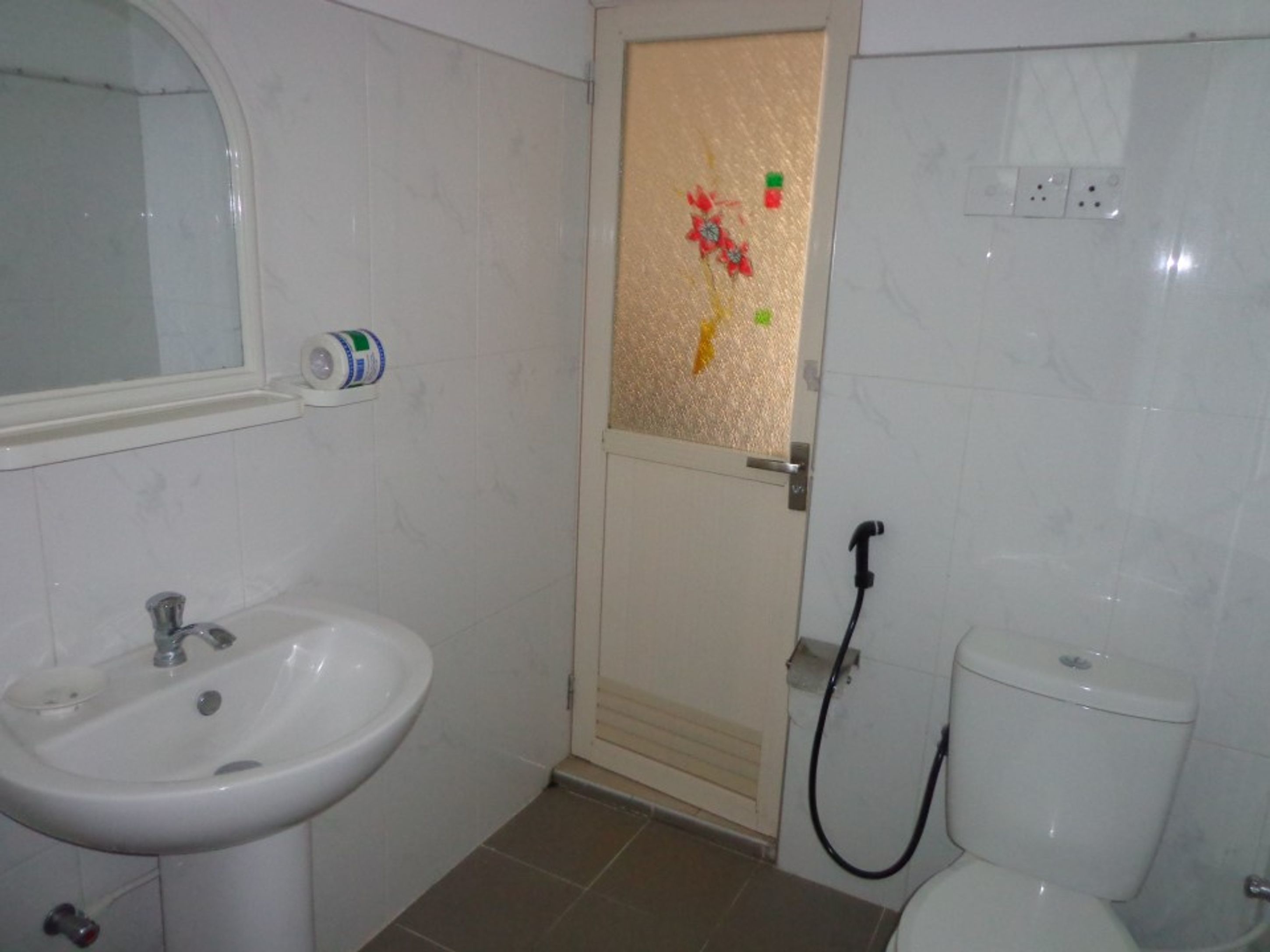 Une salle de bain comprenant un lavabo, des toilettes et un espace douche.