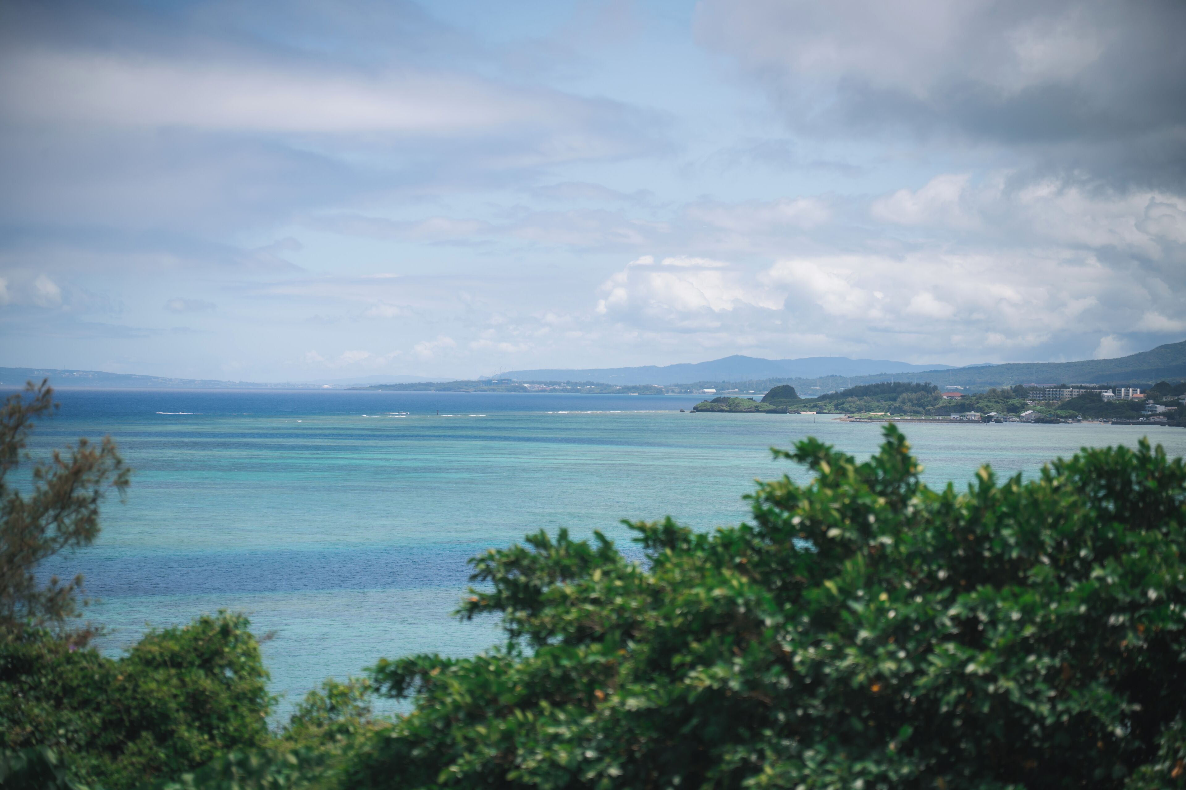 Eine Küstenlandschaft mit Blick auf das Meer und ferne Hügel.