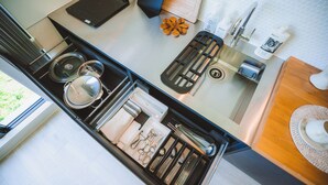 A kitchen with a built-in stove, a coffee machine, and a variety of utensils and cookware. - BLUE STEAK WONDER SENAHA (Yomitan)