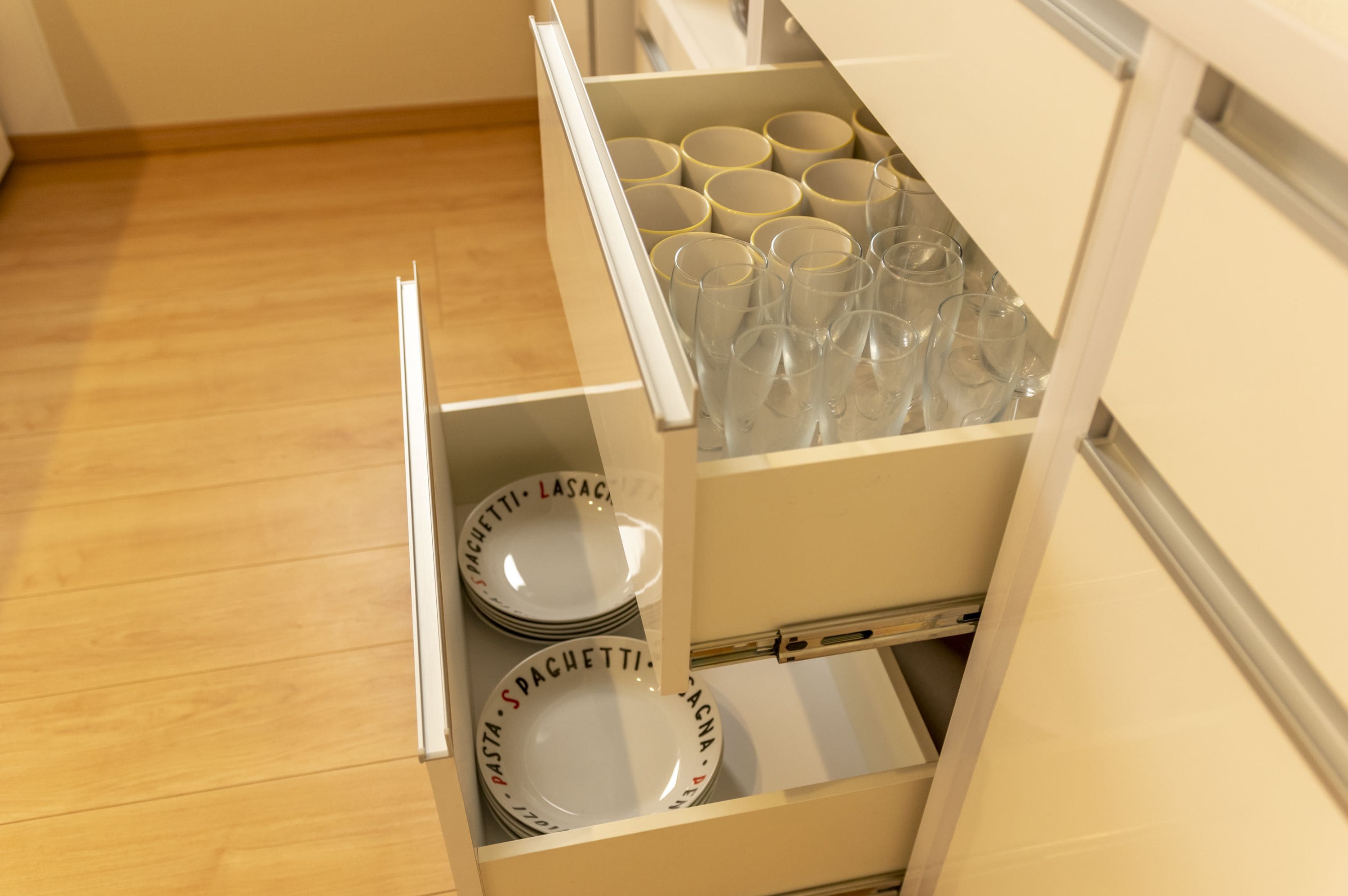A kitchen drawer with neatly organized plates and glasses.