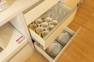 Un cajón de cocina con varias tazas y platos.