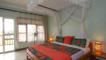 Un dormitorio con cama, cortinas, un ventilador y dos lámparas de noche.