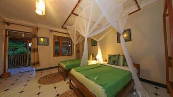 A bedroom with two beds, a mosquito net, and a view of the outside.