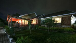 A modern house with a covered porch and a well-maintained garden.