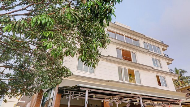 Un edificio de varios pisos con un vestíbulo cubierto y balcones.